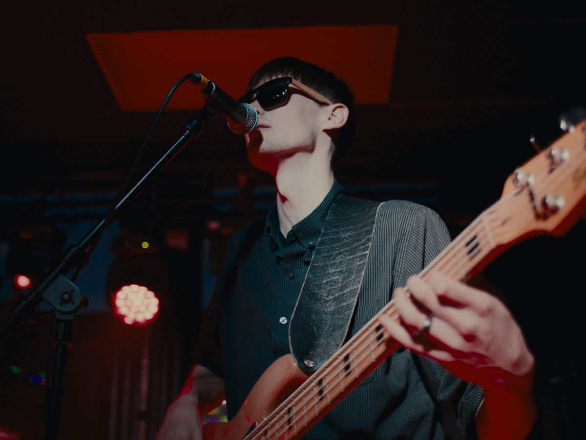 Gibson Wells singing and playing bass on stage