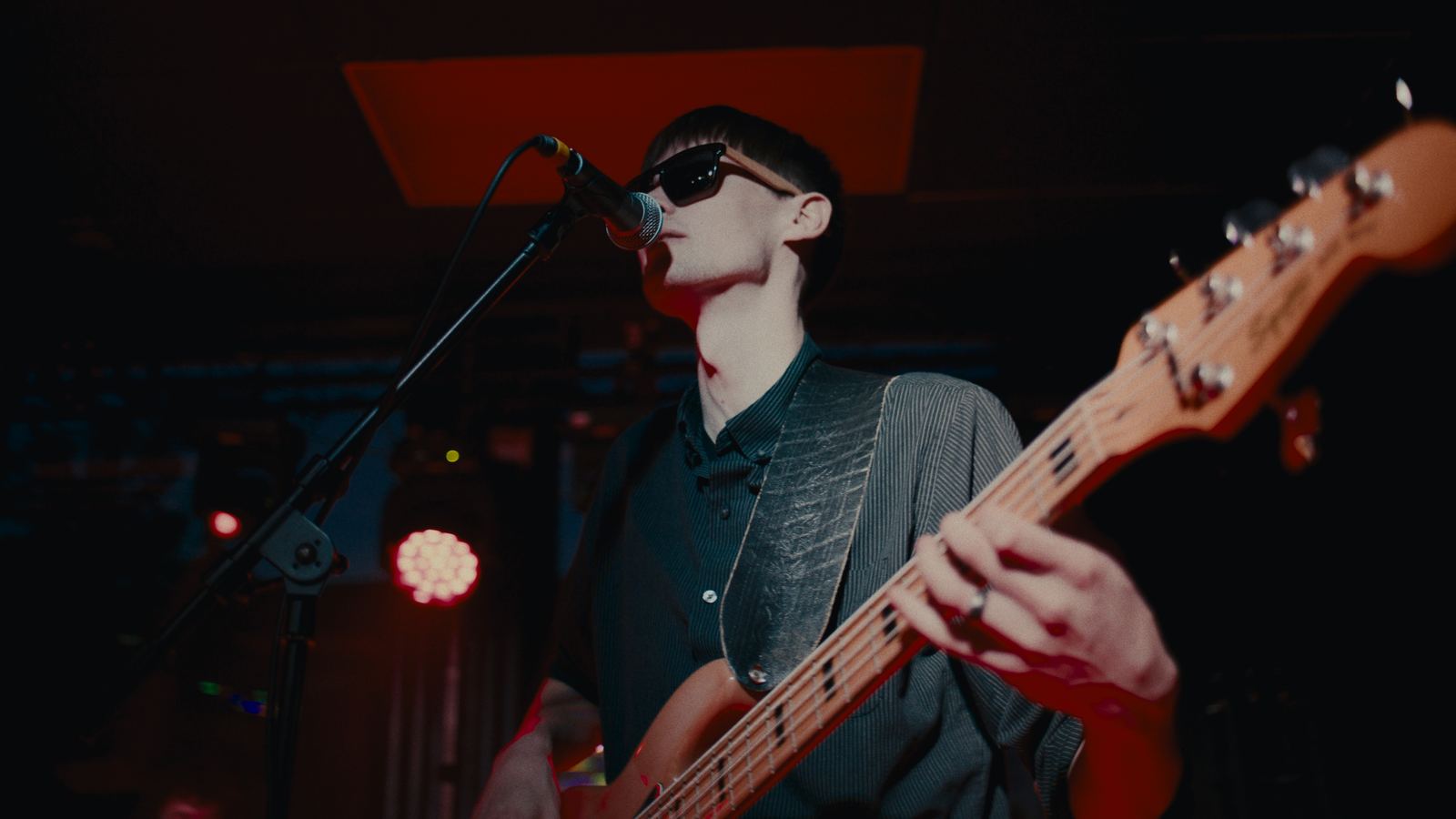 Gibson Wells singing and playing bass on stage